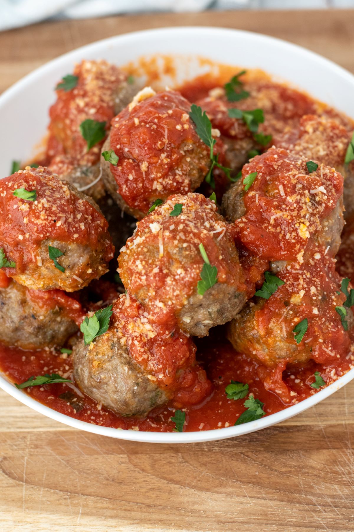 meatballs covered in marinara sauce on white plate