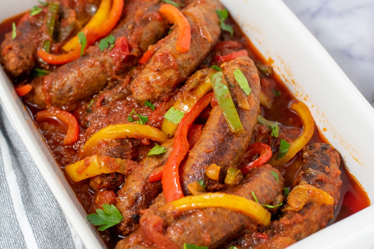sausage and peppers in white casserole dish